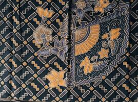 a black and yellow patterned fabric with a flower design photo