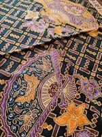 a black and purple patterned blanket with a purple and orange design photo