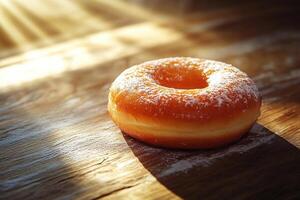 A delicious donut covered in powdered sugar lies on a wooden table in the rays of light. photo
