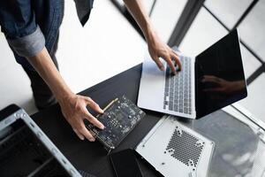 a Engineer installing Hardware typing on a laptop computer photo
