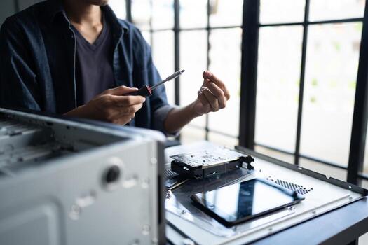 a Engineer installing Hardware is working on a computer with a screwdriver photo