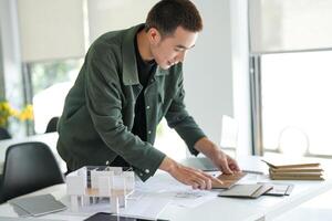 a Architecture Man working on a project at a desk photo
