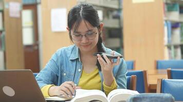 University student is asking ai voice on smartphone. Teenager talking with ai voice assistant on smartphone for researching and help her studying video