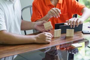 Asian father and son playing wood blocks game Carefree kid playing wood blocks building constructor from blocks with father at home. photo
