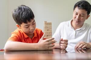 asian father and son playing with wooden blocks. photo