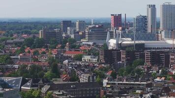 Aerial view of Eindhoven, Netherlands, featuring Philips Stadium, Vesteda Tower, modern architecture, traditional houses, and lush greenery in motion. video