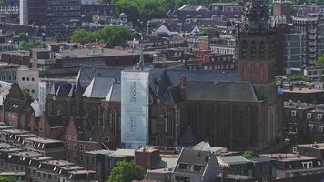Aerial view of Nijmegen, Netherlands, featuring St. Stevenskerk, red brick buildings, tiled rooftops, and greenery with a slow sweeping pan. video
