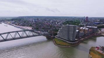 Aerial view of Nijmegen, Netherlands, featuring Waalbrug bridge, the Waal River, modern and historic architecture, and surrounding greenery. video