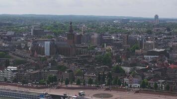 Aerial view of Nijmegen, Netherlands, featuring St. Stevenskerk, traditional Dutch buildings, modern architecture, and a circular plaza in motion. video