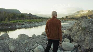 Elderly Man Admiring the Flow of a River in Nature video