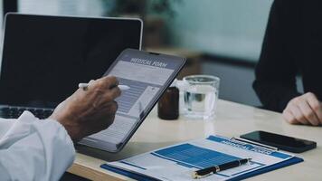 A doctor is using a tablet to take a medical history video