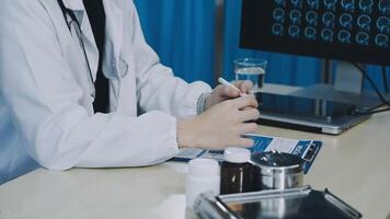 A doctor is sitting at a desk with a computer screen video