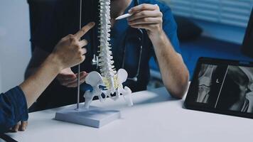 A doctor and patient working on a model of the spine video