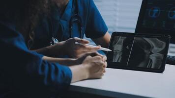 Two doctors looking at an x - ray on a tablet video