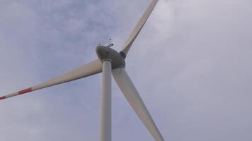 Wind turbine spinning in a clear sky at a renewable energy site video