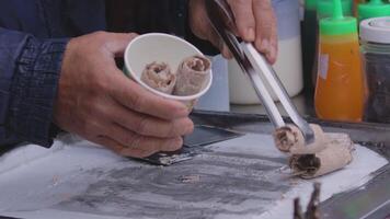Crafting rolled ice cream in a bustling street market setting video
