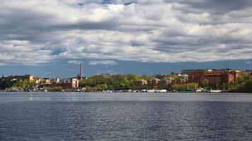 Stockholm waterfront skyline under dramatic clouds viewed across calm water in spring photo