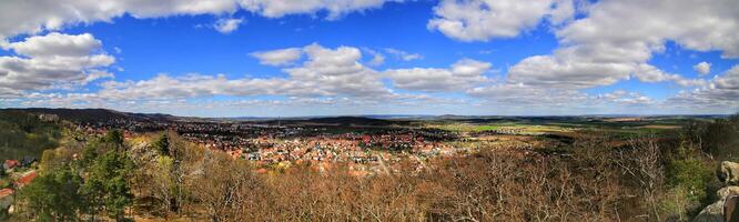 Wide valley panorama showing clustered town rooftops of Ballenstedt and open fields under scattered clouds photo