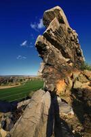 Rock formation shadow - striking vertical sandstone structure above fields near Teufelsmauer, Harz mountains photo