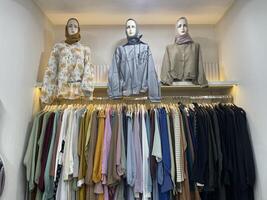 Stylish Hijab Fashion Display with Mannequins and Pastel Modest Outfits in Boutique Setting photo