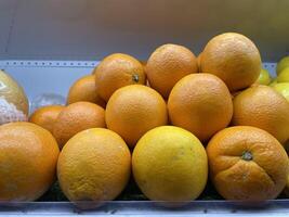 Fresh Oranges Stacked Neatly on a Market Shelf with Bright Natural Texture and Color photo