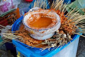 A blue bucket with skewers of food photo