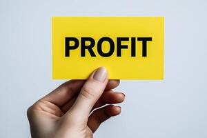 Hand holding yellow card with bold profit text, financial growth concept, business development, investment returns and marketing strategy photo
