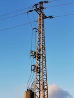 A tall power pole with wires on top photo