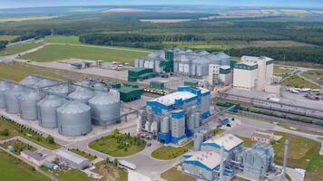 Exterior of a modern plant on a field. Large grain elevators for seed processing. New industrial area in the countryside. Aerial view. video