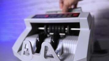 Electronic machine counting hundred dollar bills. Modern automatic equipment for counting paper currency. Money counting machine for banking and commercial activity. Slow motion. video