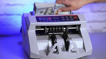 Electronic equipment for financial operations in bank. Woman's hand putting paper money into a counting machine. video