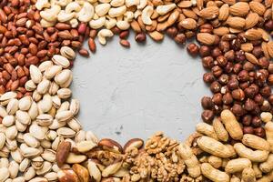 different nuts frame background. with vopy space. Walnut, pistachios, hazelnuts and cashews photo