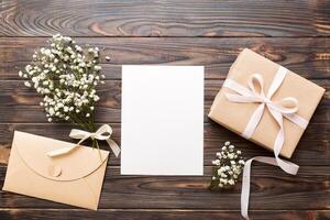 Wedding mockup with white paper list and flowers gypsophila on colored table top view flat lay. Blank greeting cards and envelopes. floral pattern. photo