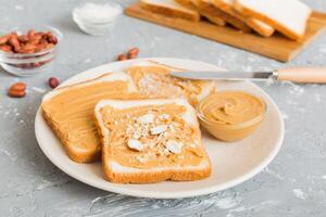 Peanut butter sandwiches or toasts on light table background.Breakfast. American cuisine top view photo