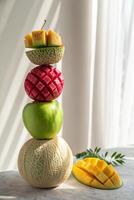 Stacked Fruit Art Displaying Mango, Cantaloupe, Apple, and Kiwi photo