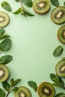 Fresh Kiwi Slices and Mint Leaves Frame on Green Background photo