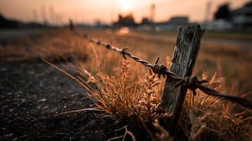 A fence with barbed wire on the side of the road photo