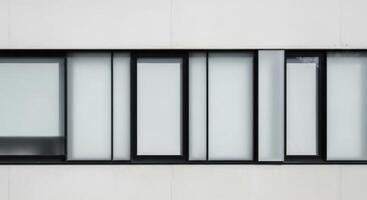 Sleek modern building exterior with black framed frosted glass window design. photo