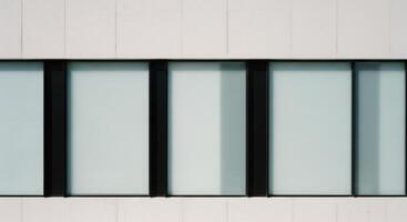 Modern minimalist building facade with frosted glass windows and sleek black frames photo