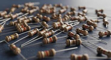 Close up of many electronic resistors scattered on a dark blue surface photo