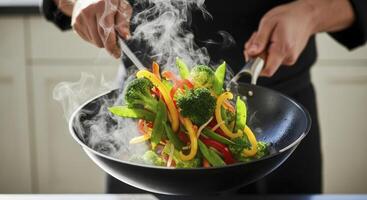 Chef tossing vibrant stir fry vegetables in a hot wok with rising steam photo