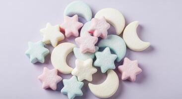 Sweet pastel star and moon shaped marshmallows scattered on a purple surface photo