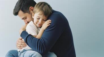 Close up of a tender moment as a father lovingly embraces his young son, showcasing family affection. photo