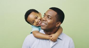 Smiling african american father and son hugging in a joyful studio portrait photo