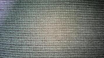 Detailed macro shot of a grey fabric, showcasing its complex weave and subtle variations in tone. The image emphasizes texture and pattern. photo