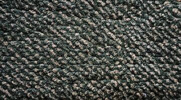 A close up of a green rug with a pattern photo