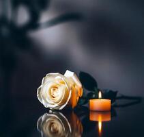 Elegant White Rose with Candle on Reflective Surface in Dark Mood Lighting photo
