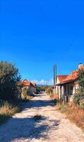 Idyllic Village Street Scene in Summer with Rustic Houses and Bright Blue Sky overhead rural charm photo
