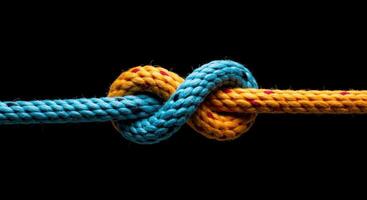 Colorful nautical knot ties two ropes together symbolizing connection strength and problem solving on black background photo