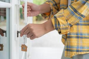 Landlord key for unlocking house is plugged into the door. Second hand house for rent and sale. Owner use hand unlock door mortgage for new home, buy, sell, renovate, investment, owner. photo